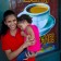 Young woman holds baby in front of coffee shop